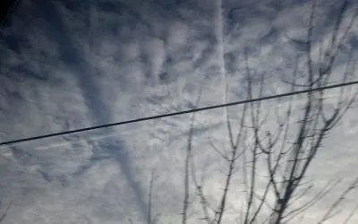 High altitude Chemtrail casting shadow on lower altitude clouds